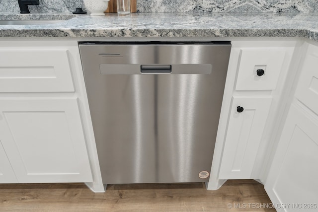 203 W Monroe Ave, Mcalester, OK 74501 - detailed view of dishwasher, white cabinetry, and wood finished floors