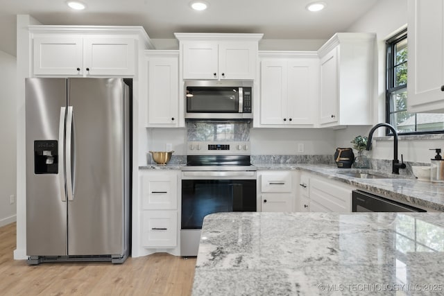 203 W Monroe Ave, Mcalester, OK 74501 - kitchen with appliances with stainless steel finishes, a sink, white cabinets, light wood-style flooring, and light stone countertops
