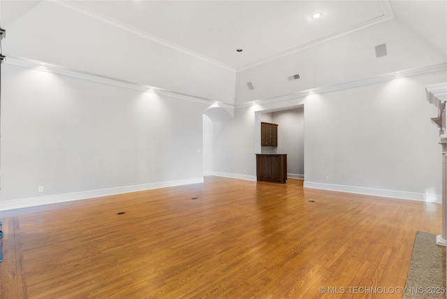 unfurnished living room with hardwood / wood-style flooring, ornamental molding, and a high ceiling