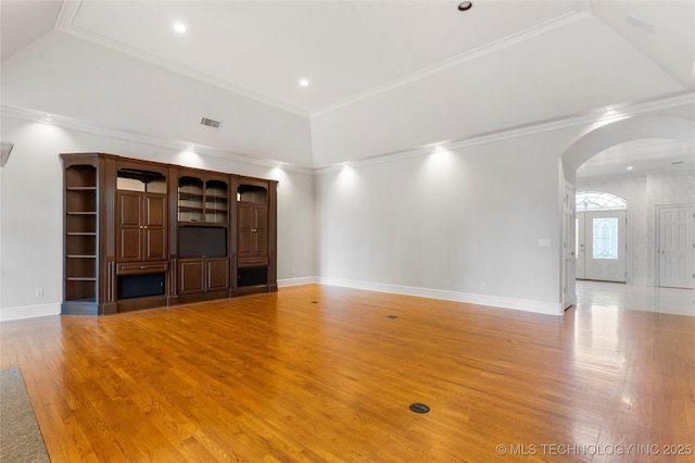 unfurnished living room featuring a high ceiling, wood-type flooring, and crown molding