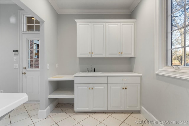 interior space with sink, light tile patterned floors, and ornamental molding