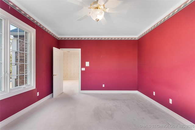 spare room with crown molding, light carpet, and ceiling fan