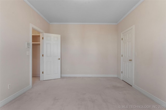 empty room featuring crown molding and light colored carpet