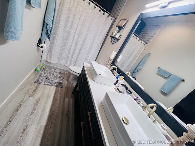 full bathroom featuring shower / bath combo with shower curtain, wood-type flooring, toilet, and vanity