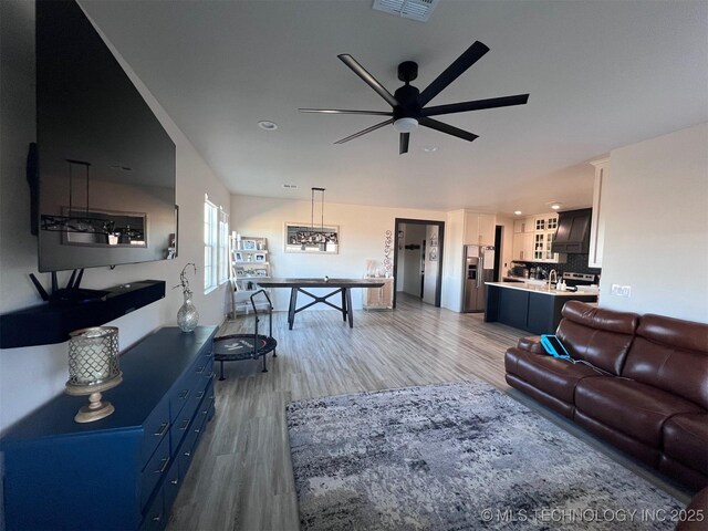 living room with wood-type flooring and ceiling fan