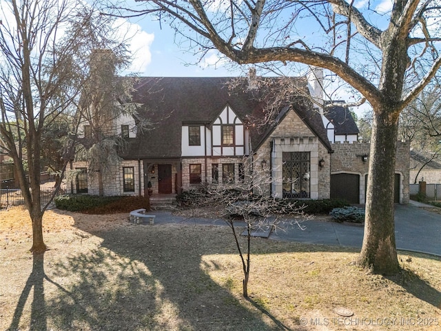 tudor-style house with a front lawn