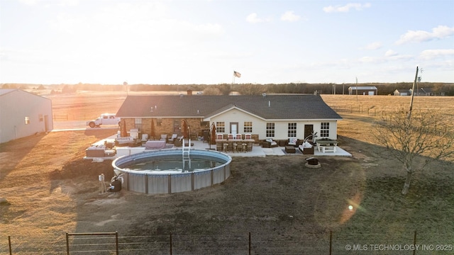 rear view of house with a fenced in pool, outdoor lounge area, and a patio