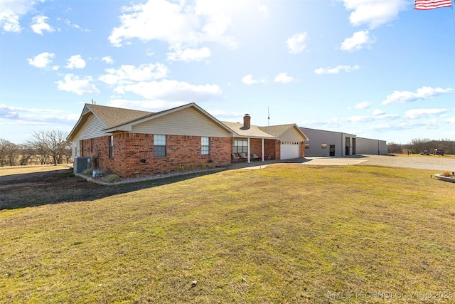 single story home featuring cooling unit, a garage, and a front yard