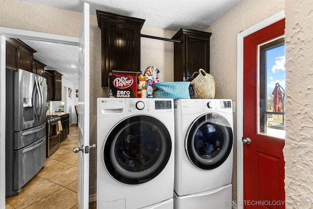 washroom featuring cabinets, light tile patterned flooring, washer and dryer, and a textured ceiling