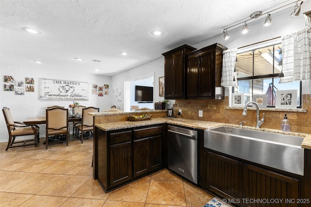 kitchen featuring dishwasher, sink, backsplash, light stone counters, and kitchen peninsula