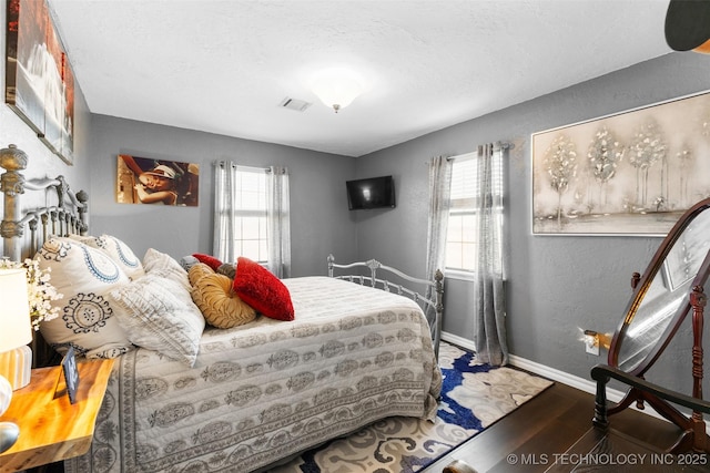 bedroom featuring dark wood-type flooring and a textured ceiling