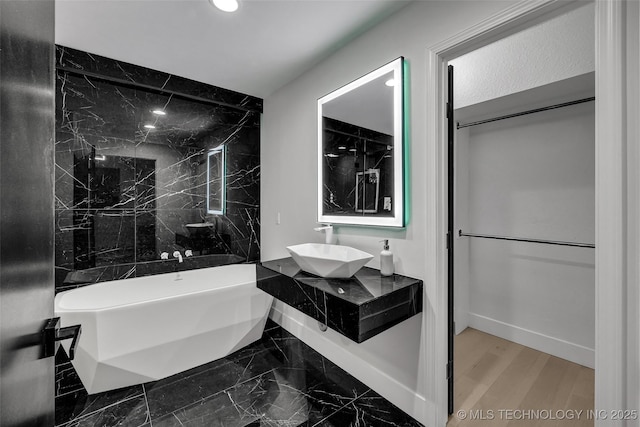 bathroom with sink and a washtub