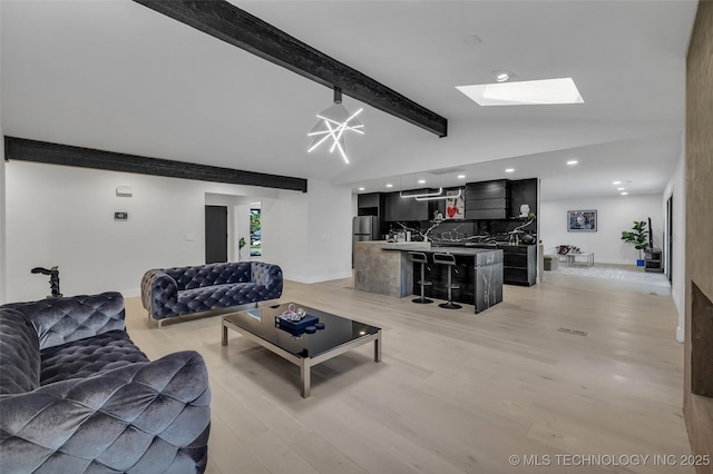 living room with light hardwood / wood-style flooring and lofted ceiling with skylight