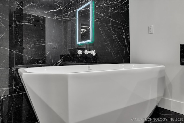 bathroom featuring a bathtub and tile walls