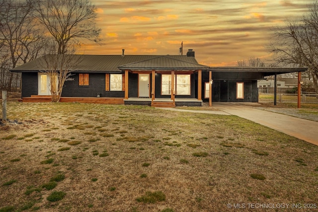31915 E 723rd Dr, Wagoner, OK 74467 - view of front of house with a chimney, driveway, an attached carport, metal roof, and covered porch