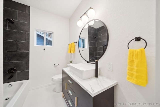 full bathroom featuring vanity, tiled shower / bath, and toilet