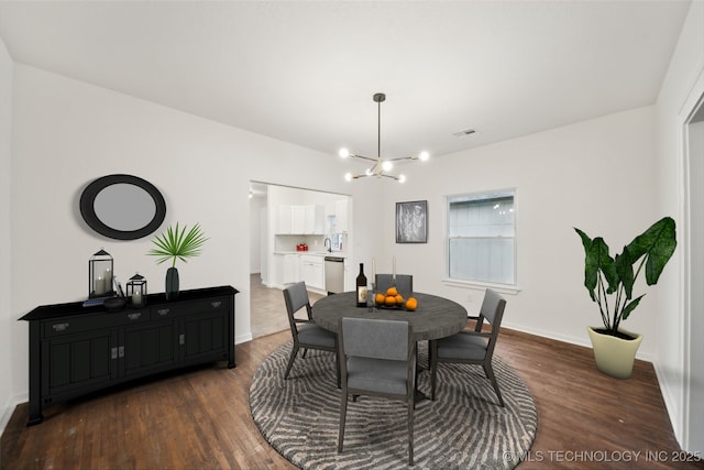 dining room with dark hardwood / wood-style floors, a chandelier, and sink