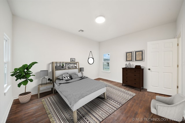 bedroom with dark hardwood / wood-style flooring