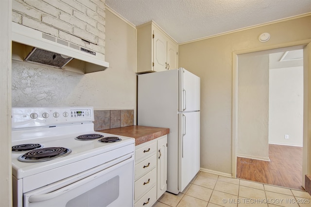 kitchen with white cabinetry, light tile patterned floors, a textured ceiling, and white appliances