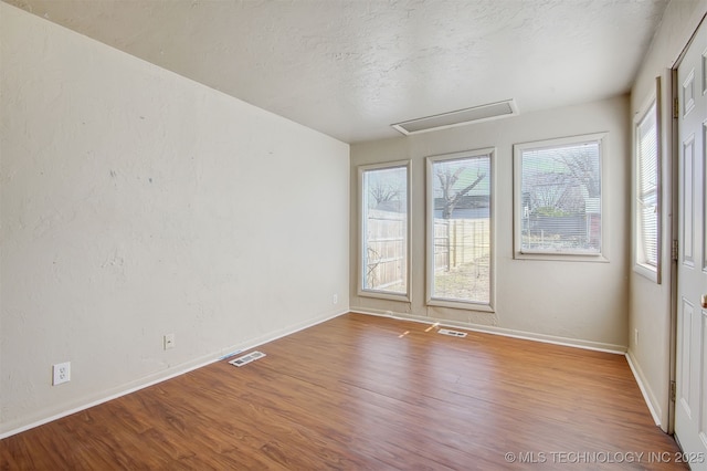 empty room featuring hardwood / wood-style flooring and a textured ceiling