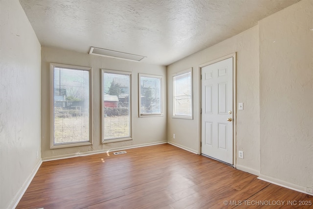 spare room with hardwood / wood-style floors and a textured ceiling