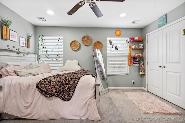 bedroom with ceiling fan, a closet, and light carpet