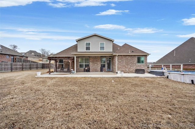 back of house featuring a fenced in pool, a patio, and a lawn