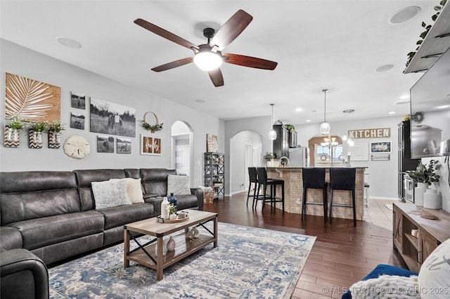 living room with ceiling fan and dark hardwood / wood-style flooring