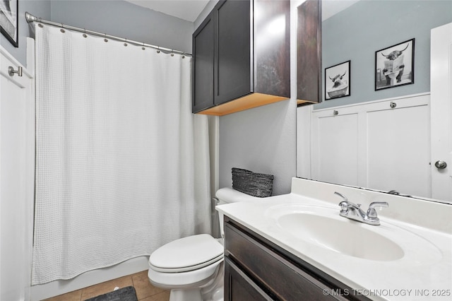 bathroom with tile patterned flooring, vanity, and toilet