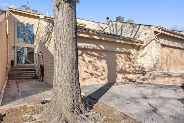 view of property exterior with a garage and a patio area