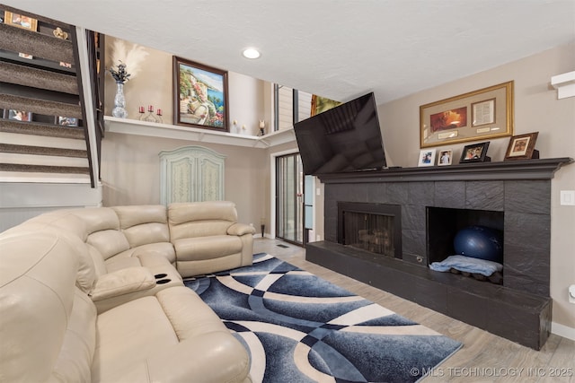 living room with hardwood / wood-style flooring and a tile fireplace