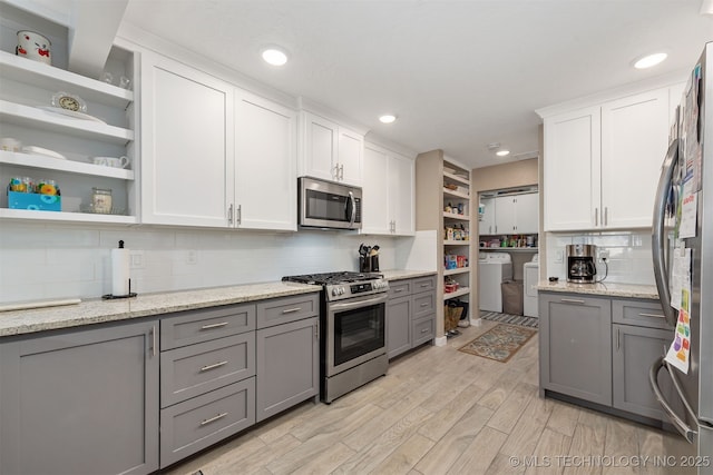 kitchen featuring gray cabinetry, independent washer and dryer, stainless steel appliances, and white cabinets