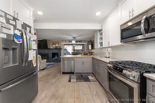 kitchen featuring gray cabinets, light stone countertops, white cabinets, and appliances with stainless steel finishes