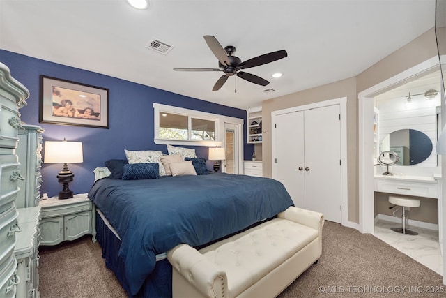 bedroom with built in desk, a closet, ceiling fan, and ensuite bathroom