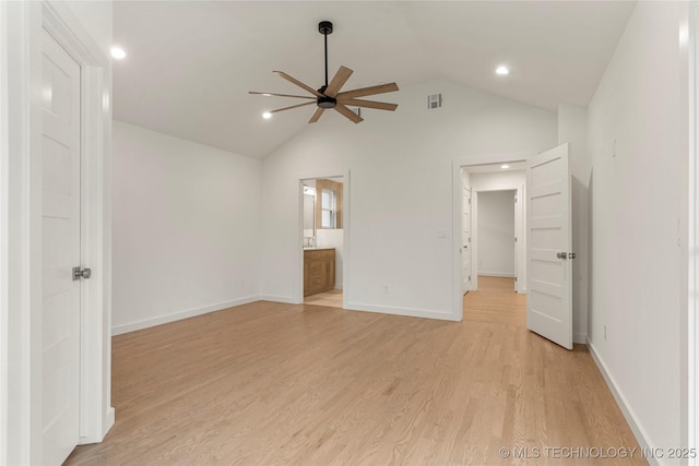 unfurnished bedroom featuring ceiling fan, ensuite bathroom, vaulted ceiling, and light hardwood / wood-style flooring