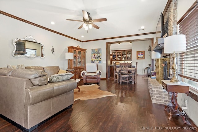 living room with dark wood-type flooring, ceiling fan, and ornamental molding