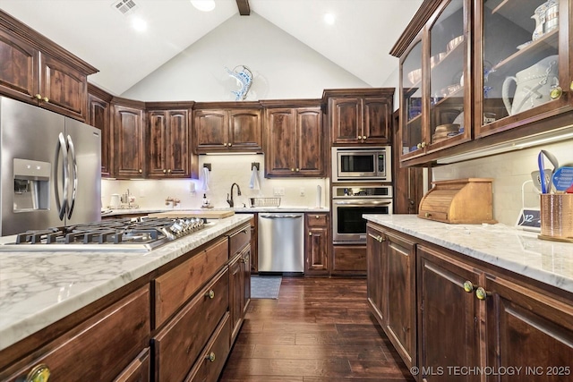 kitchen featuring dark brown cabinetry, appliances with stainless steel finishes, and dark hardwood / wood-style floors