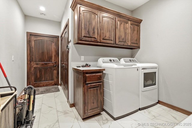 laundry room featuring cabinets and washer and clothes dryer