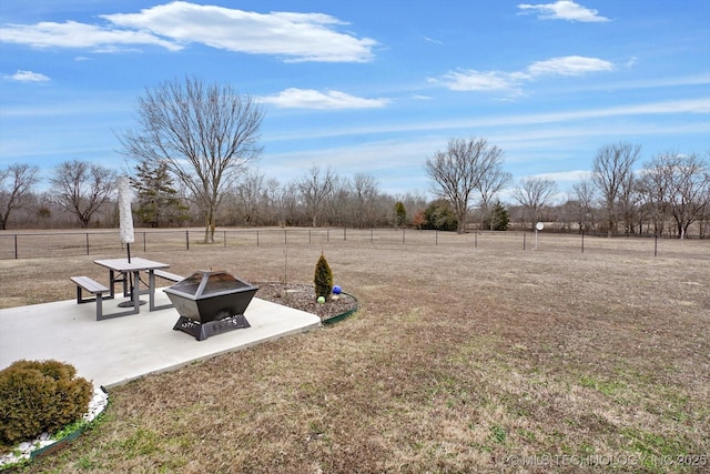 view of yard with a rural view, a fire pit, and a patio area