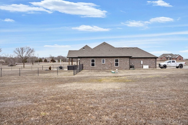 back of property with a lawn and central air condition unit