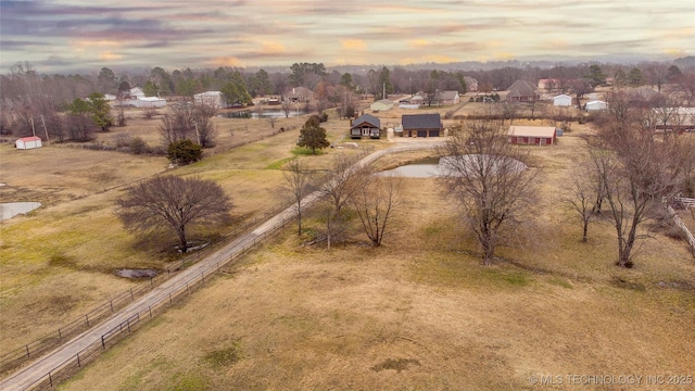 aerial view at dusk featuring a water view