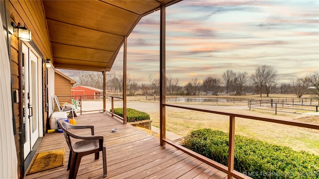 deck at dusk featuring a rural view