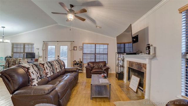 living room with vaulted ceiling, ornamental molding, a fireplace, and light hardwood / wood-style floors