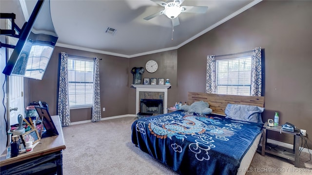 bedroom featuring ceiling fan, carpet, ornamental molding, a tiled fireplace, and vaulted ceiling