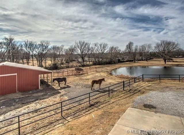 view of yard with an outbuilding, a water view, and a rural view