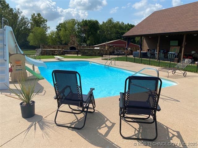 view of pool featuring a fireplace and a patio area