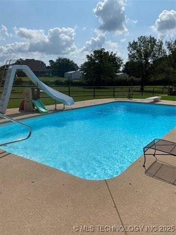 view of pool featuring a water slide and a diving board