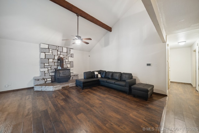 living room featuring dark wood-type flooring, high vaulted ceiling, a wood stove, ceiling fan, and beam ceiling