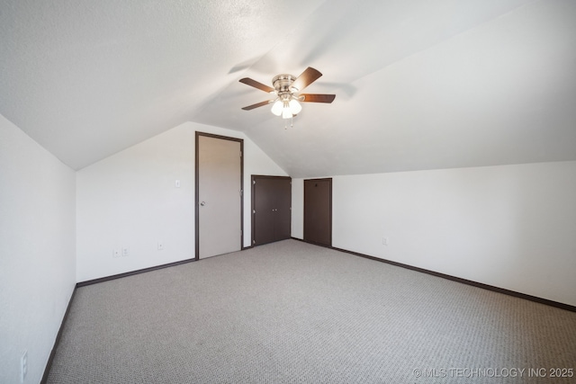 bonus room with ceiling fan, lofted ceiling, light carpet, and a textured ceiling