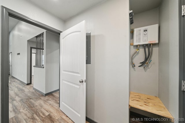 hallway with light hardwood / wood-style floors and electric panel